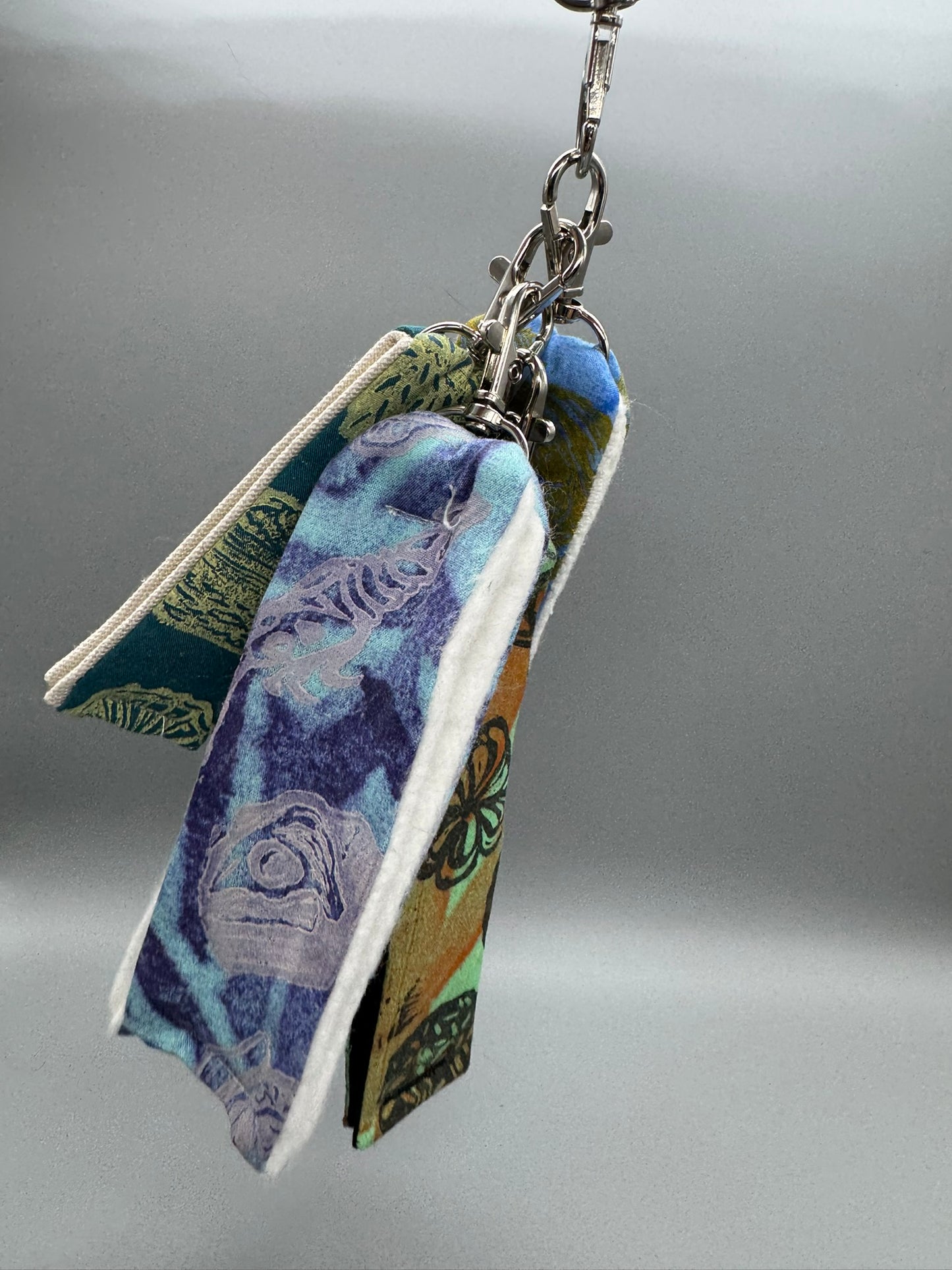 Keychain with fabric strip featuring a blue and green pattern on a gray background
