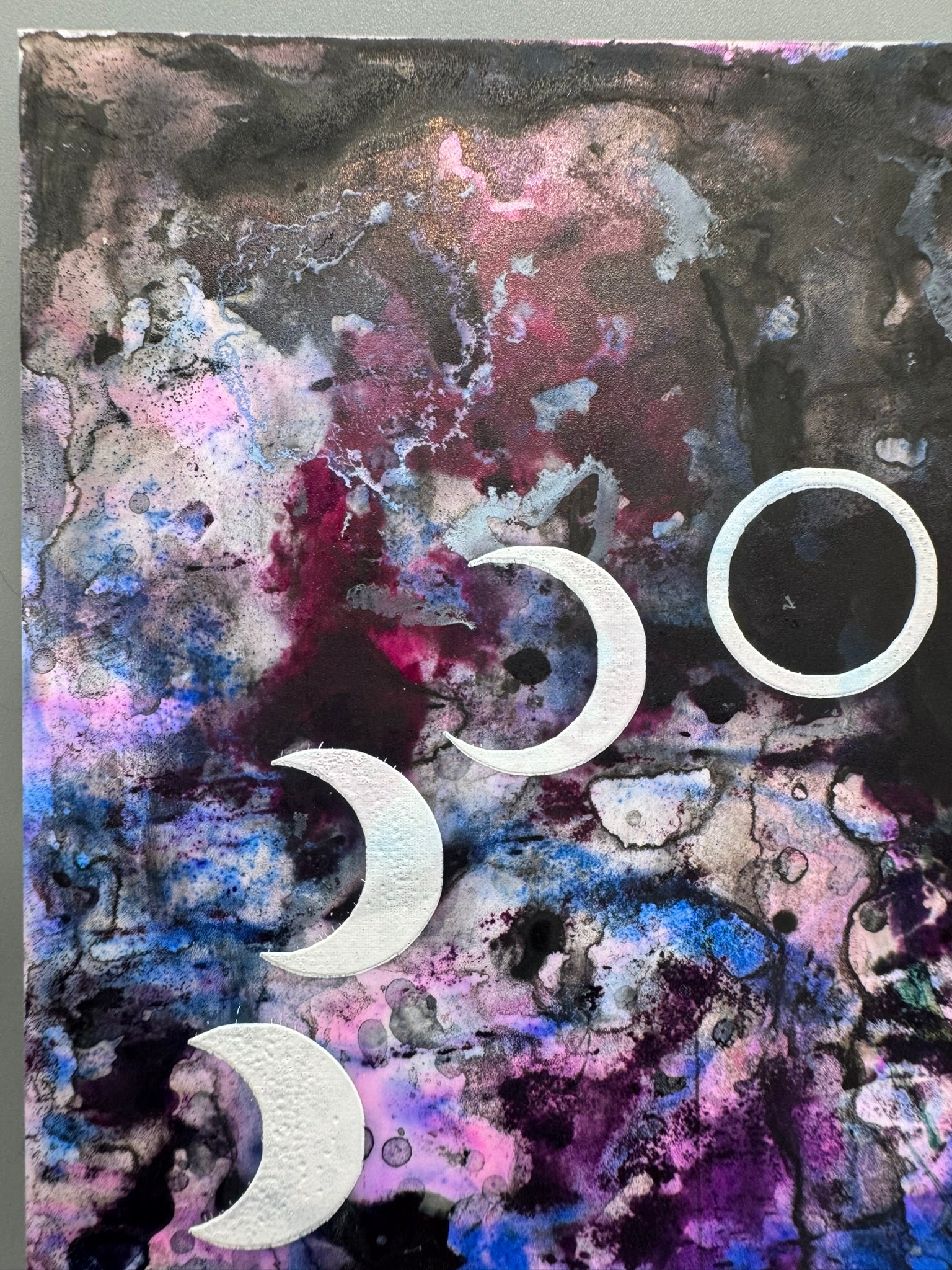 Abstract art with cosmic design and white moon phases on a textured background