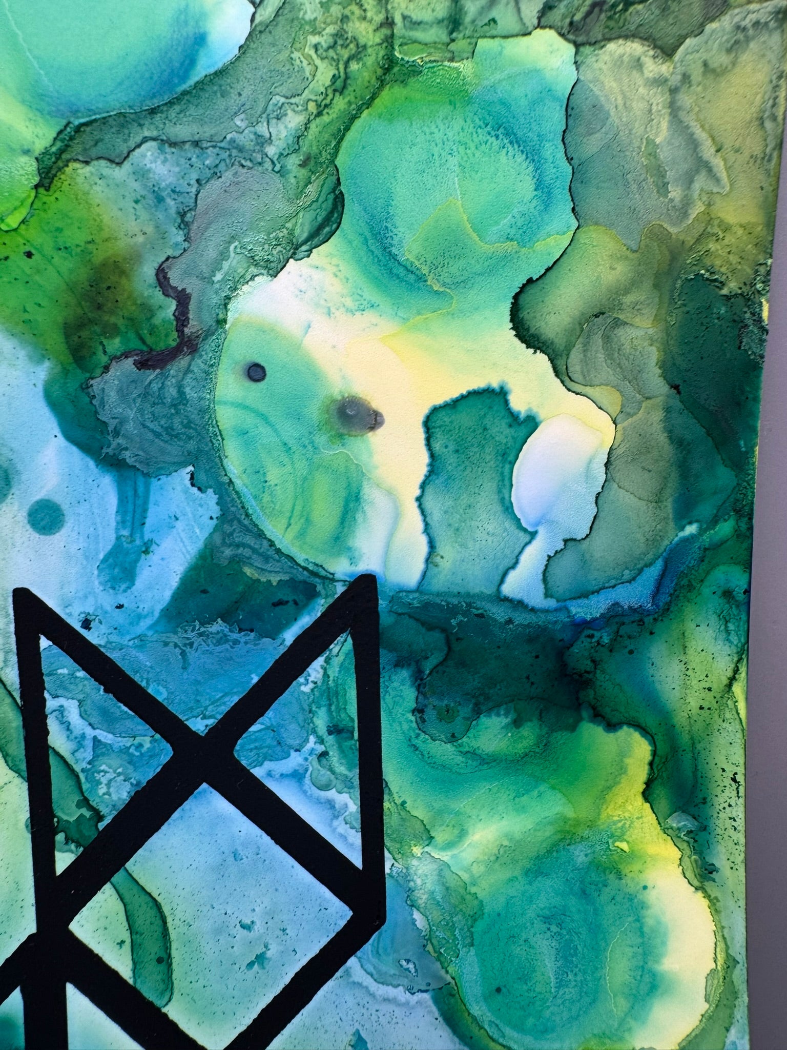 Abstract art with green and blue colors and a black symbol on a white background