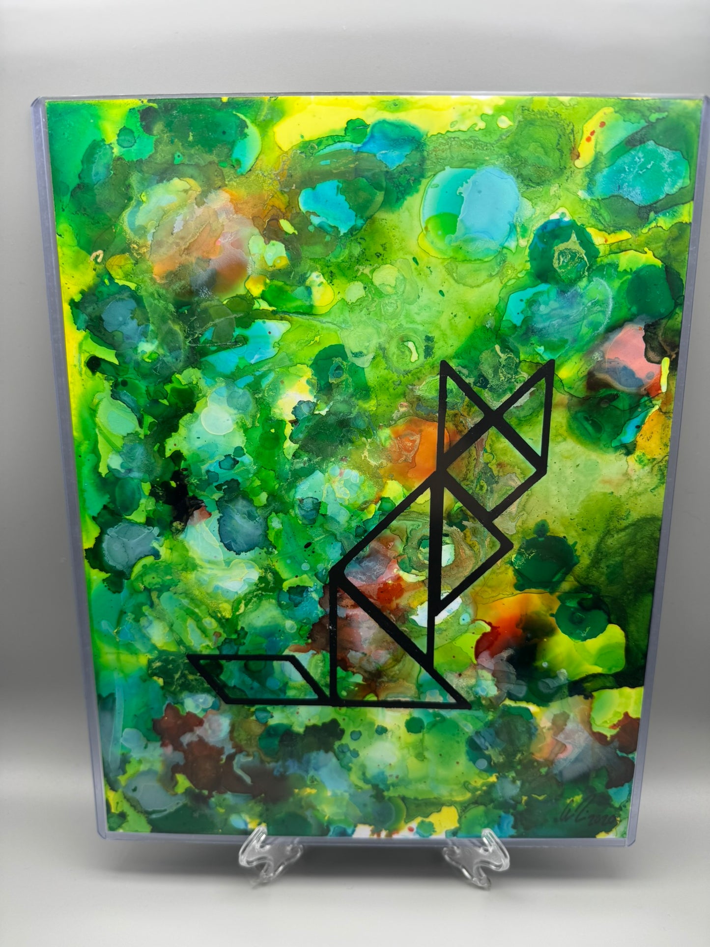 Abstract art piece with a black geometric design on a colorful background