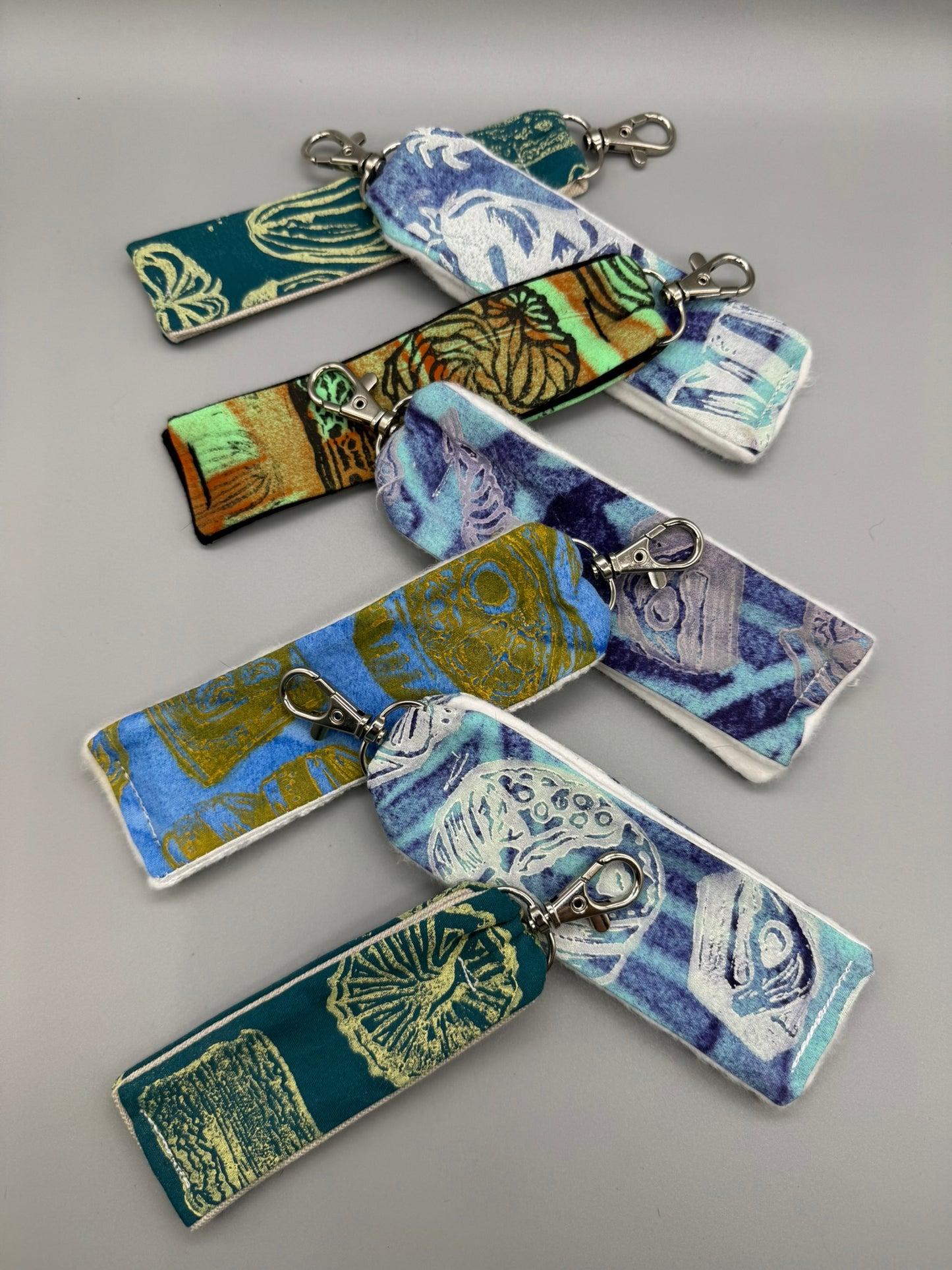 Set of colorful fabric keychains on a gray background